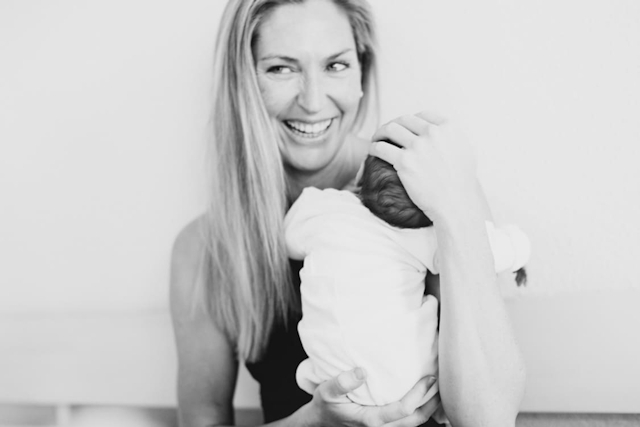 Mutter hält Neugeborenes im Arm. Schwarz-weiß Fotografie.