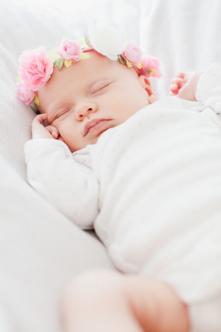 Schlafendes Baby mit Blumenkranz
