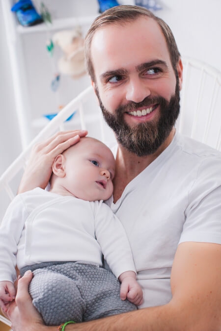 Vater hält sein Baby im Arm und lacht