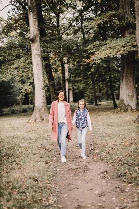 Mutter mit ihrer Tochter laufen im Wald