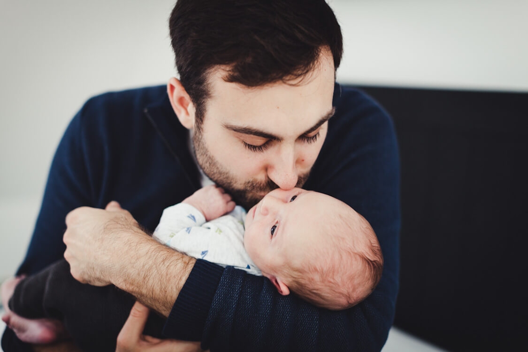Vater küsst seinen neugeborenen Sohn