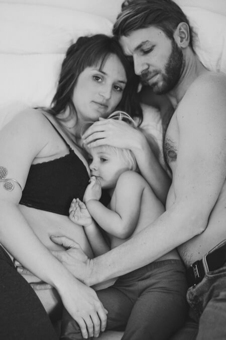 Familie kuschelt mit Babybauch von Mama