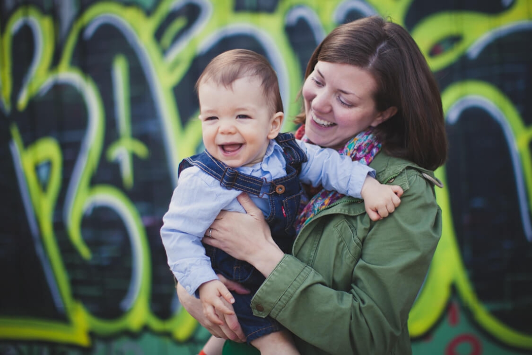 Mutter und kleiner Sohn mit Grafiti im Hintergrund