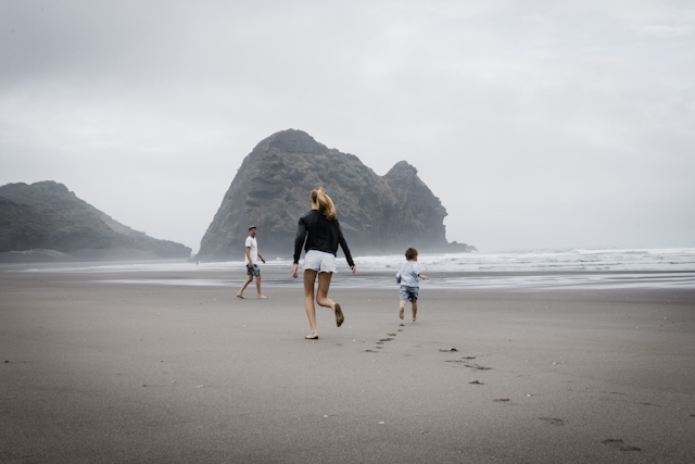 Familie rennt über einen Sandstrand