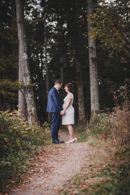 Brautpaar steht in einer Waldlichtung