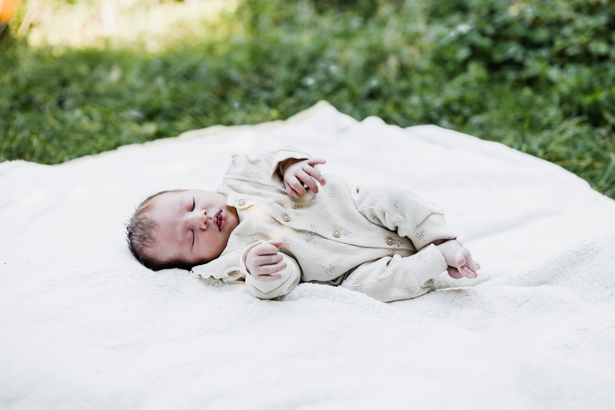 Baby auf einer Decke im Garten