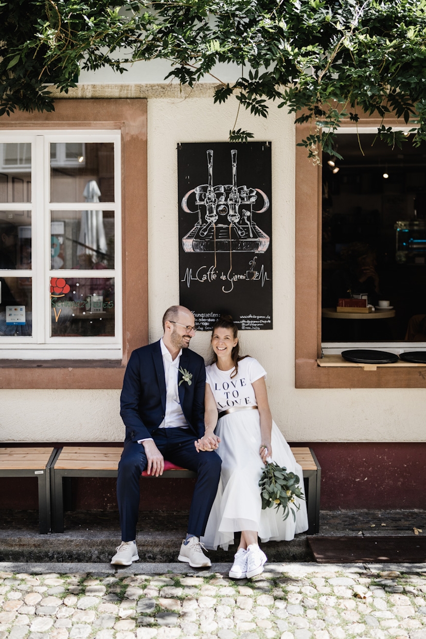 Brautpaar sitzt in einem Straßencafe