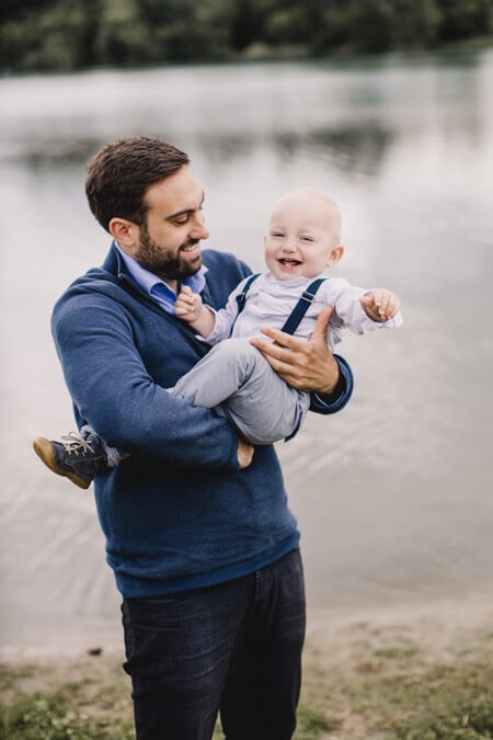 Vater mit Sohn auf dem Arm an einem See