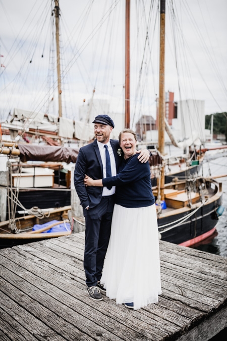 Brautpaar steht vor einer Hafenkulisse