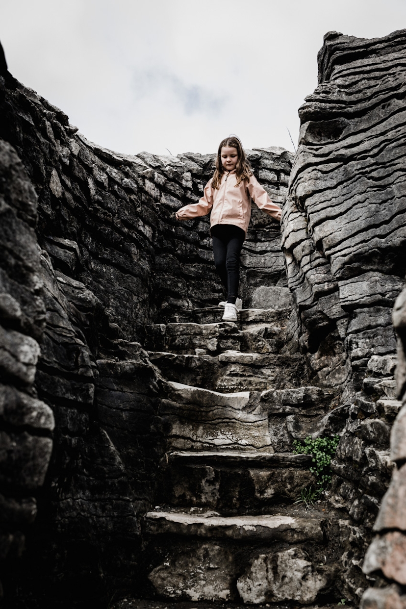 Mädchen geht eine Treppe aus Stein runter