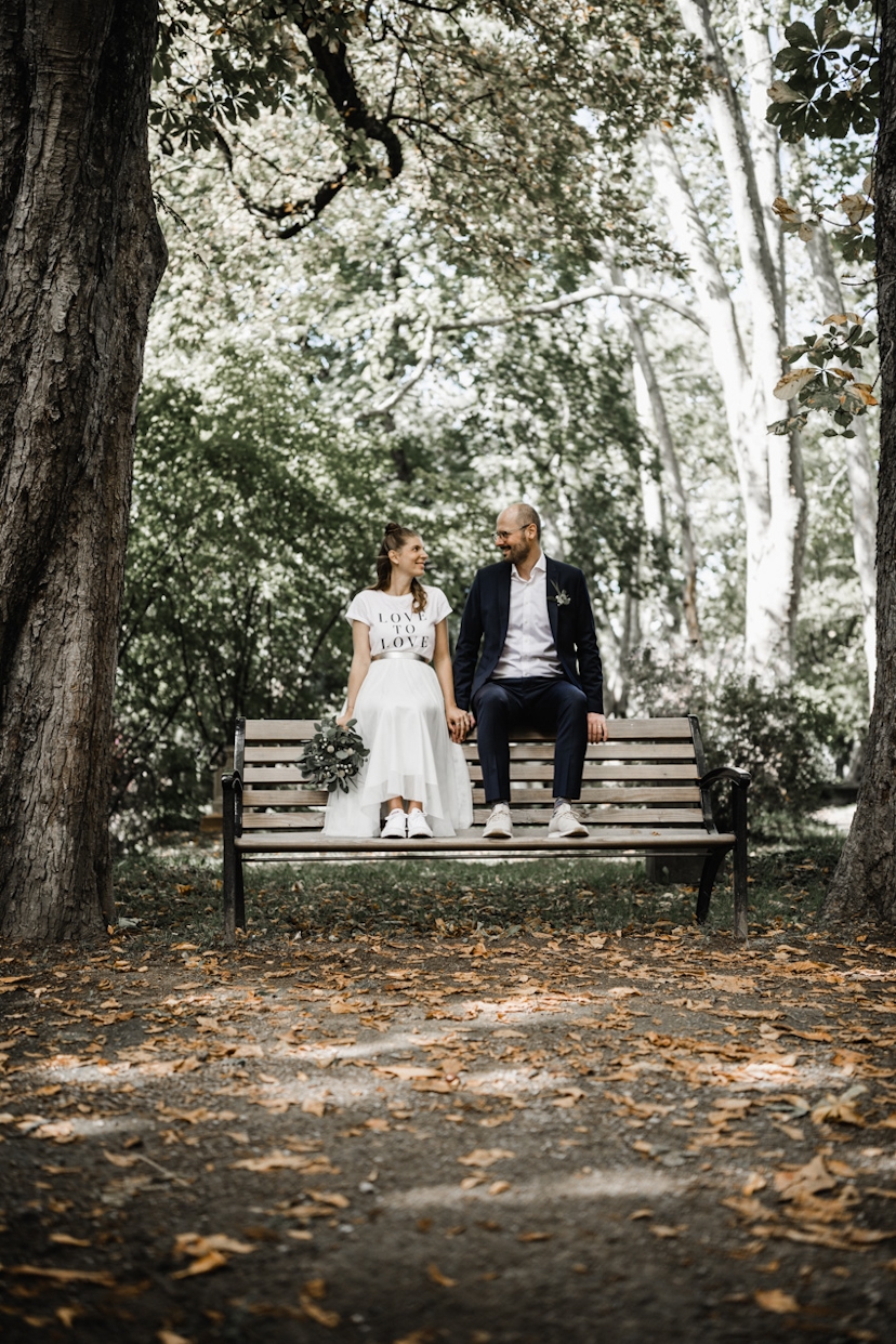 Brautpaar sitzt auf einer Parkbank