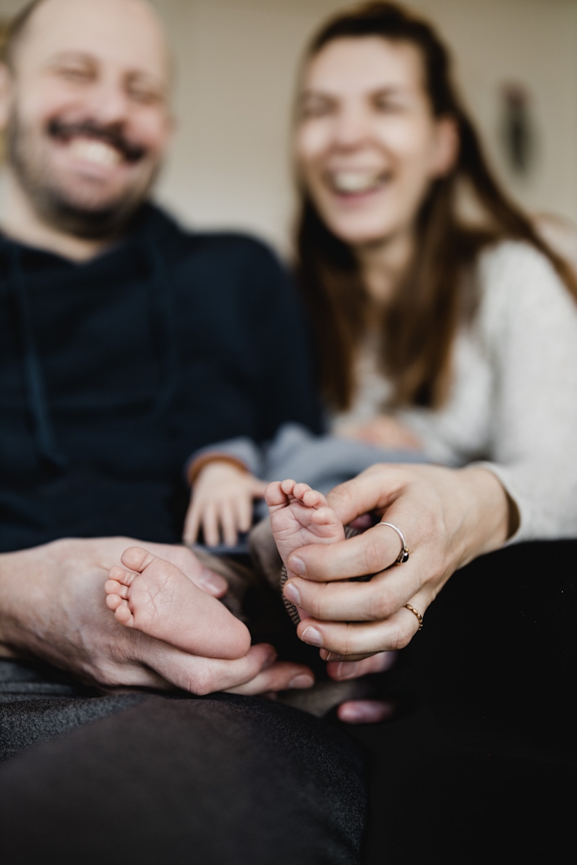 Eltern halten die Füße von ihrem Baby in den Händen