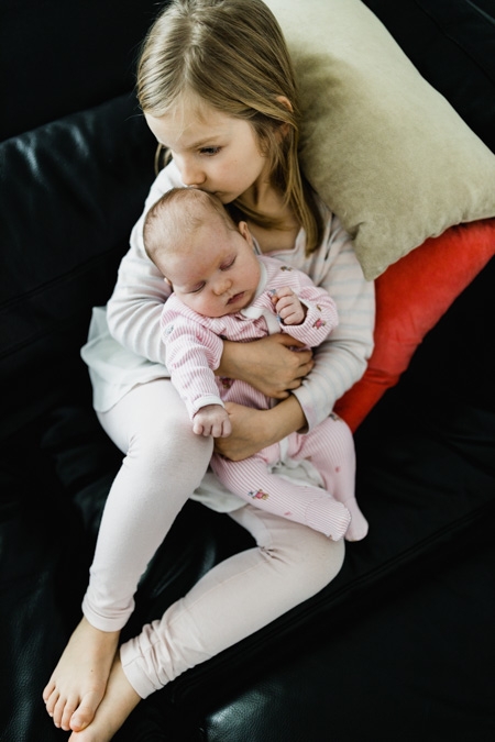 Schwester hält Baby auf dem Arm