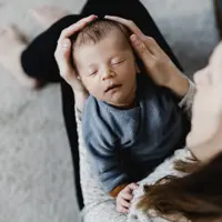 Neugeborenen-Fotoshooting in Freiburg - Baby wird von Mutter gehalten